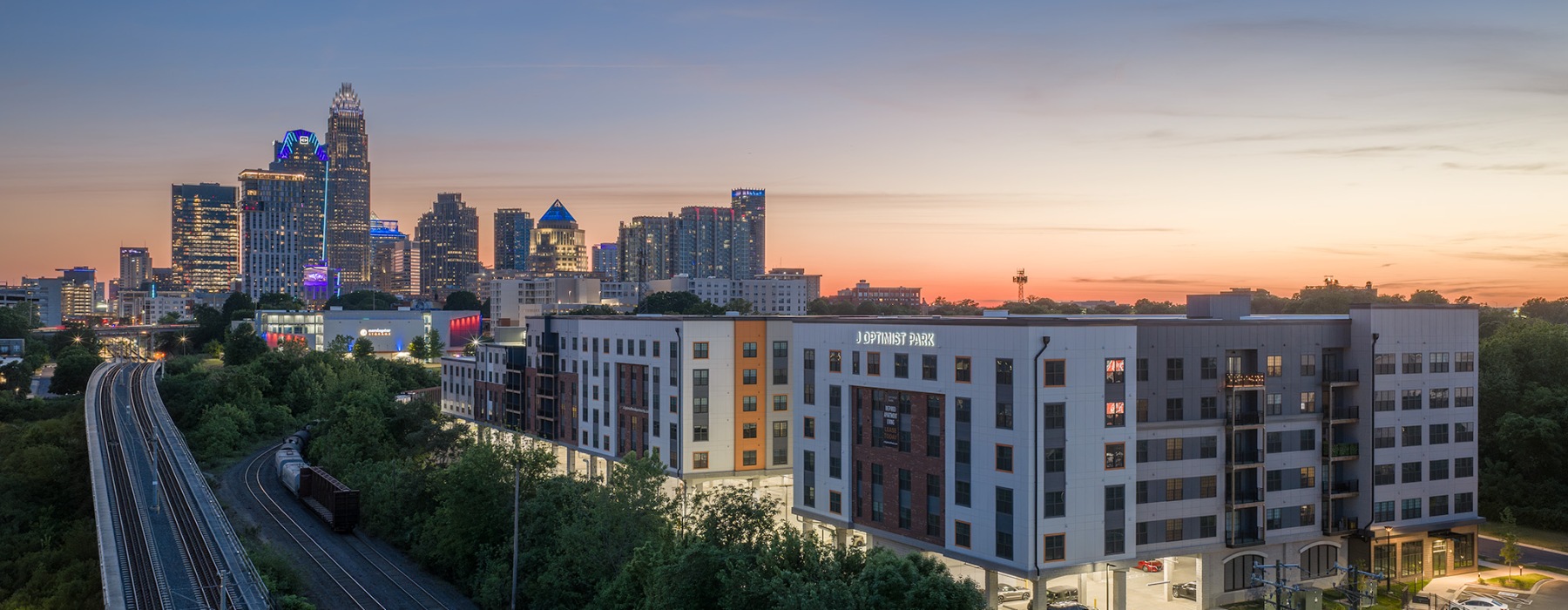 evening aerial view of J Optimist Park Apartments with Charlotte Skyline