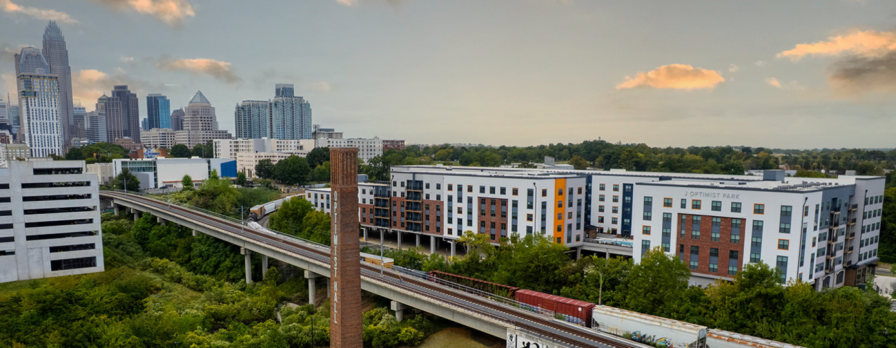 Apartments near Charlotte skyline and Optimist Hall in Forground 